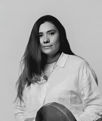 Black and white portrait of a woman with long hair wearing a light-colored shirt.